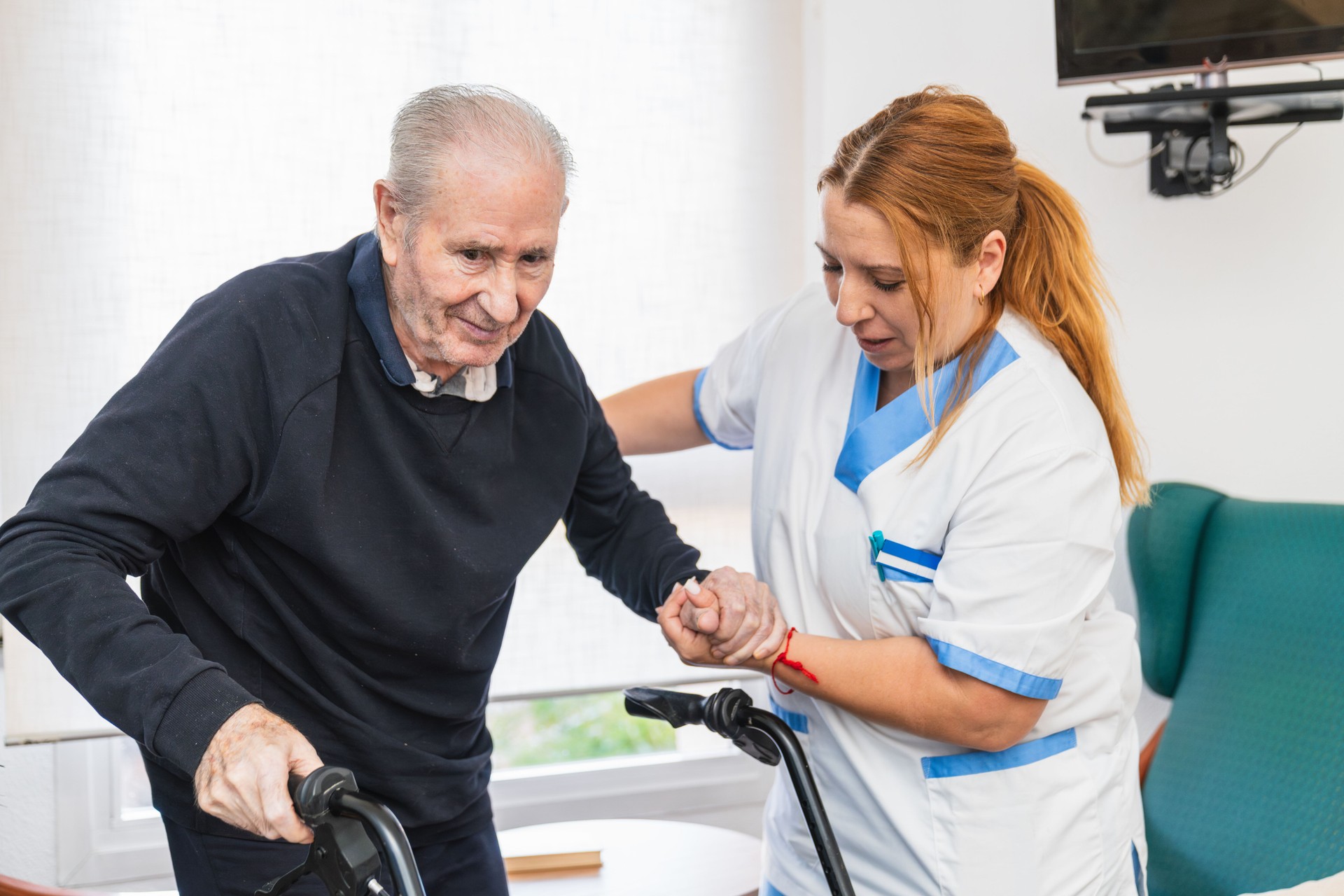 Caring nurse assisting elderly man with walker